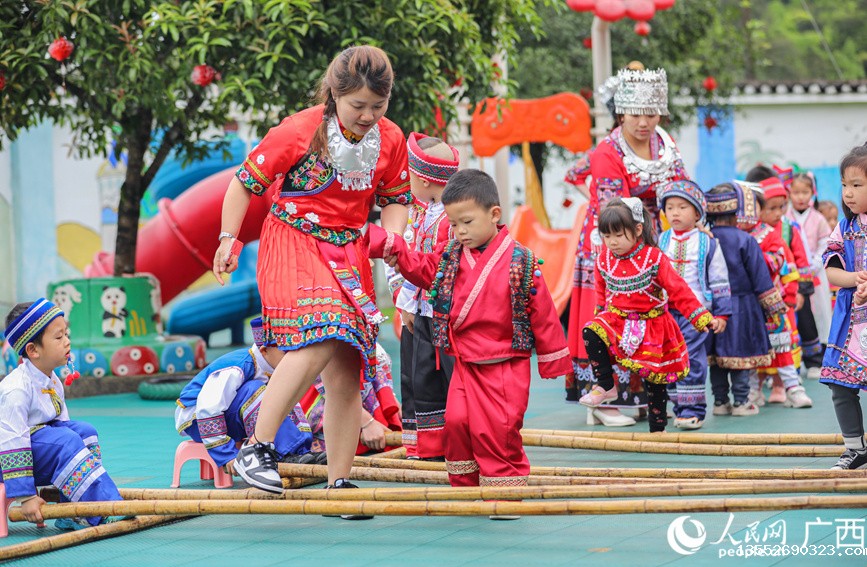 老师和孩子们穿着民族服饰跳竹竿舞。人民网记者 陈燕摄
