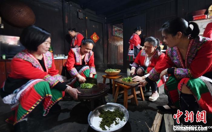 3月14日，在广西桂林市龙胜各族自治县马堤乡马堤村民合瑶寨，村民将艾草磨碎后加入糯米粉。　潘志祥 摄