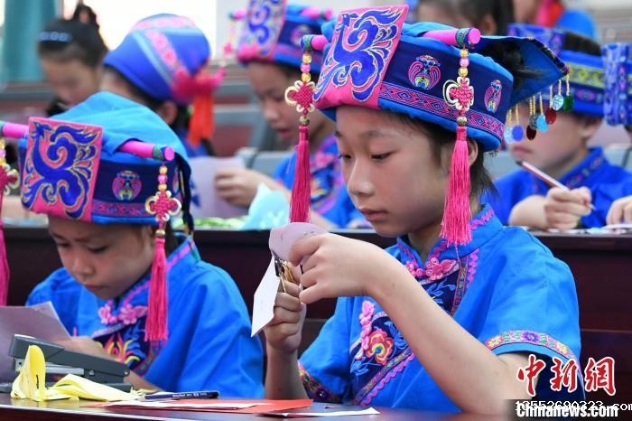 图为学生在学习仫佬族剪纸技艺。 廖光福 摄 图为学生在学习仫佬族剪纸技艺。 廖光福 摄