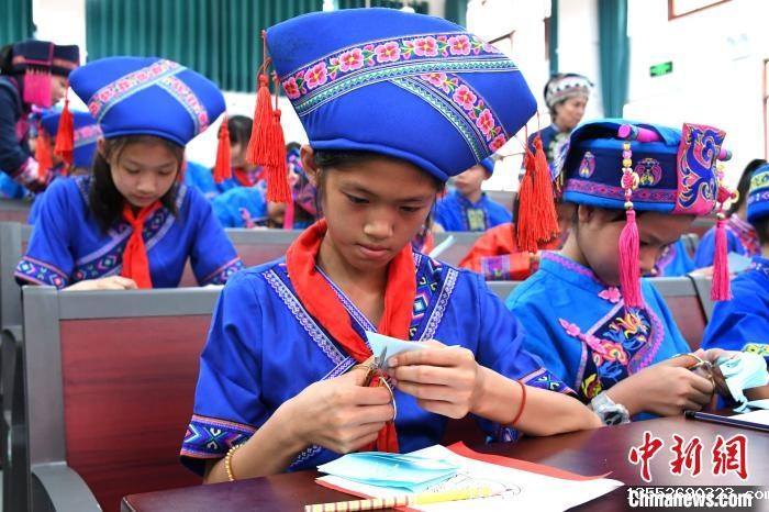 图为学生在学习仫佬族剪纸技艺。 廖光福 摄 图为学生在学习仫佬族剪纸技艺。 廖光福 摄