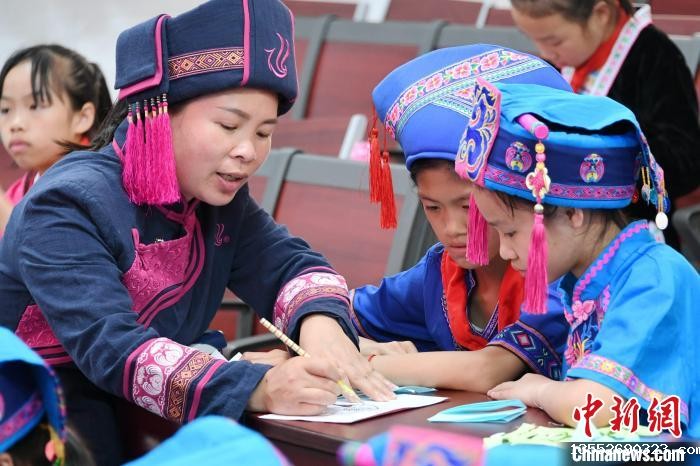 图为仫佬族剪纸艺人在指导学生学习仫佬族剪纸技艺。 廖光福 摄 图为仫佬族剪纸艺人在指导学生学习仫佬族剪纸技艺。 廖光福 摄