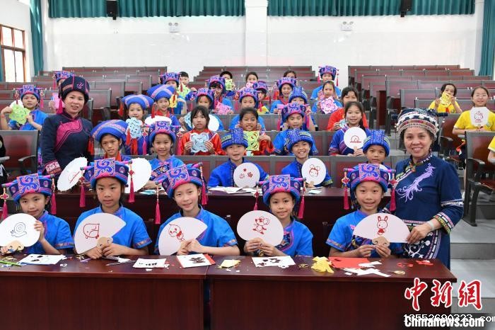 图为学生们在展示自己的仫佬族剪纸及文创作品。 廖光福 摄 图为学生们在展示自己的仫佬族剪纸及文创作品。 廖光福 摄