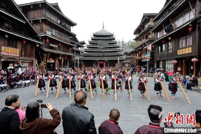 12月13日，在广西三江侗族自治县林溪镇程阳八寨景区，侗族妇女在吹地筒。龚普康 摄